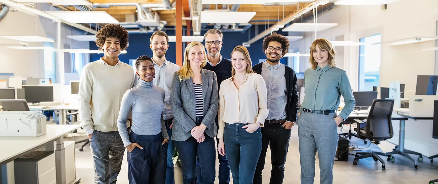 A smiling team standing together in their office
